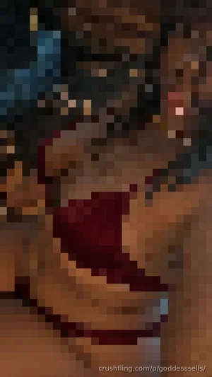 Close-up of a woman with dark hair and red lips, indoors.