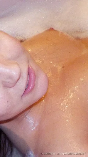 Close-up of a person's shoulder and neck with soap suds, likely in a shower.