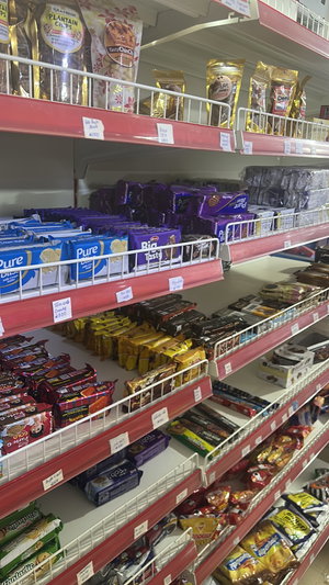 Supermarket shelves stocked with packaged snacks and candies.