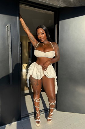 Woman in white lace outfit posing in doorway.