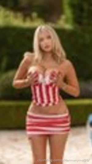 Blonde woman in red and white striped outfit standing outdoors.