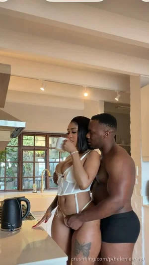 Woman in white lingerie and man in black underwear embracing in a kitchen.