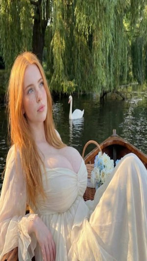 Redhead woman in white dress on boat in lake setting