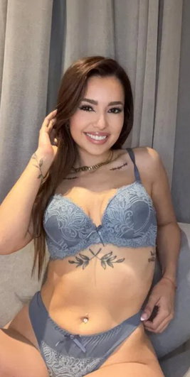 Smiling woman with brown hair in blue lingerie indoors.