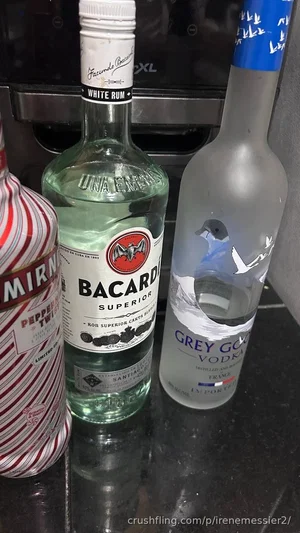 Three liquor bottles on a dark countertop: Mirinda, Bacardi, and Grey Goose.