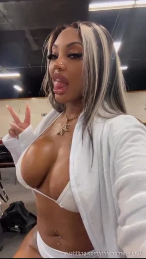 Woman with blonde and black hair in white lingerie and robe, posing indoors.
