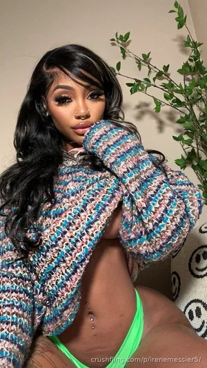 Woman with long black hair in colorful knit sweater and neon green underwear, sitting indoors near