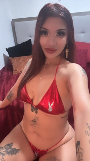 Woman with long red hair in red bikini on bed.