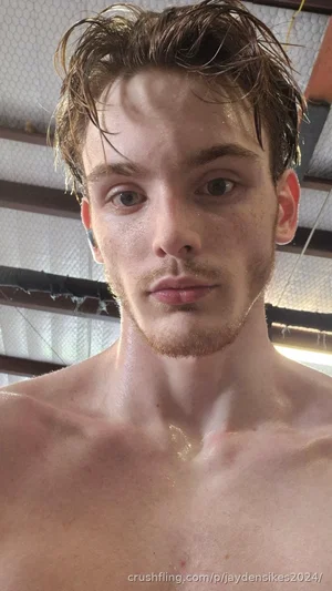 Shirtless man with wet hair and stubble, indoors, close-up selfie.