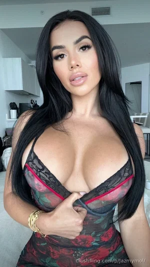 Woman with long black hair in floral lace lingerie, posing indoors.
