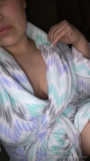 Woman in patterned robe, partially unbuttoned, showing chest area, indoor setting.