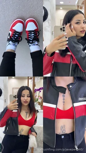 Woman in red crop top and black jacket with tattoos, taking mirror selfies indoors.