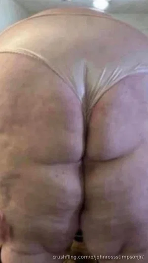 Back view of a person in white underwear, showing buttocks and lower back, indoors.