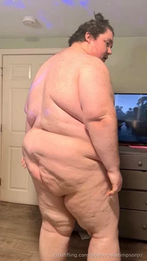person with curvy body standing bareback in indoor room, facing away from camera.