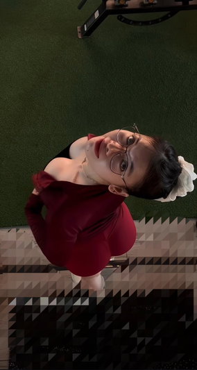Woman with glasses in red top taking indoor selfie