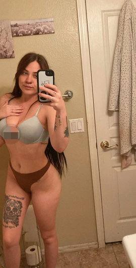 Woman in light gray bra and brown underwear taking mirror selfie in bathroom.
