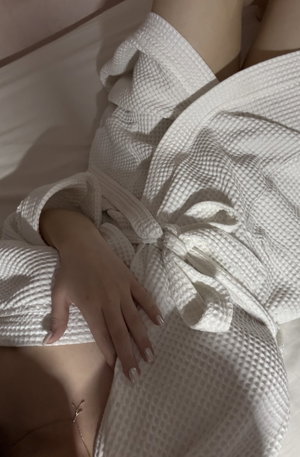 Person in white robe lying on bed.