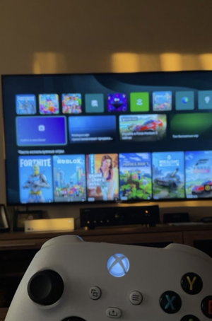 Gaming setup with TV showing games and Xbox controller.