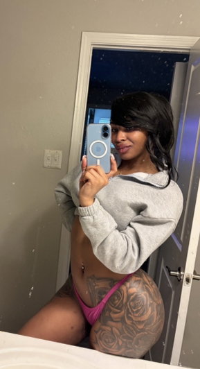 Woman in pink underwear taking mirror selfie in bathroom.