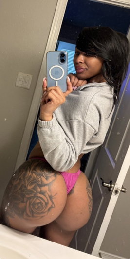 Woman in grey hoodie and pink underwear taking mirror selfie in bathroom.
