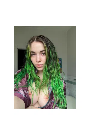 Woman with green hair in a purple robe, topless, in a bathroom setting.