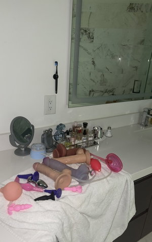 Bathroom counter with sex toys and toiletries.