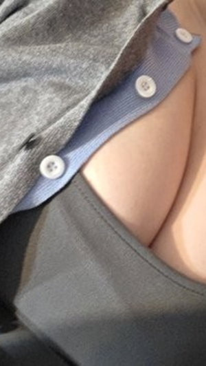 Close-up of person wearing layered shirts, showing skin between fabric layers.