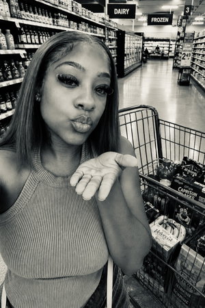 Curvy woman in tank top selfie in supermarket.