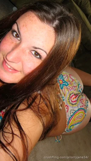 Woman with long brown hair in colorful patterned underwear, lying on carpet indoors.