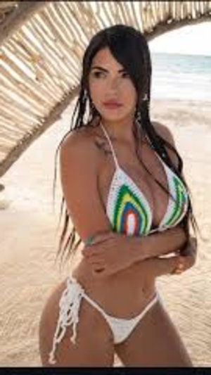 Brunette in crochet bikini on beach.