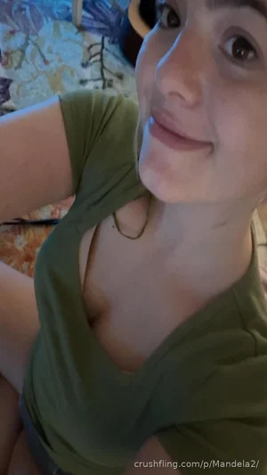 Woman in olive green top, smiling, indoor setting, close-up selfie.