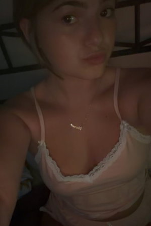 Woman in pink lace lingerie in bedroom.
