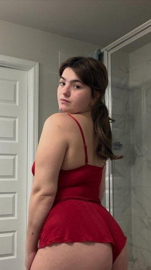 Woman in red lingerie posing in bathroom.