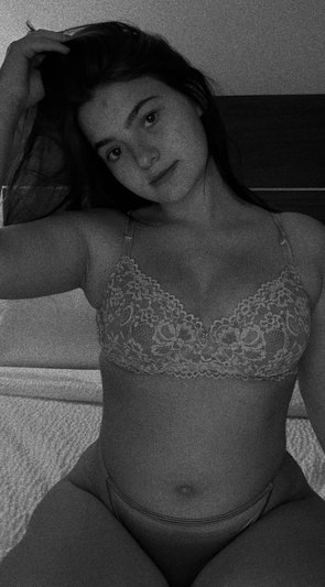 Woman in lace lingerie posing on a bed.