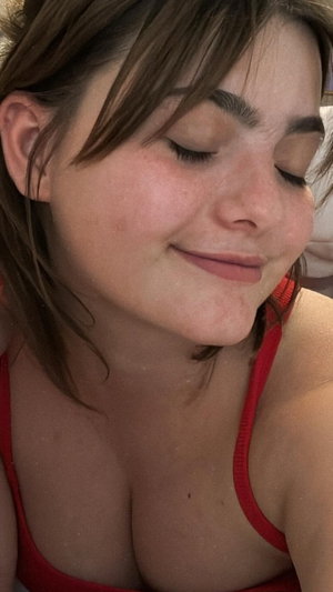 Close-up of woman with brown hair in red top.