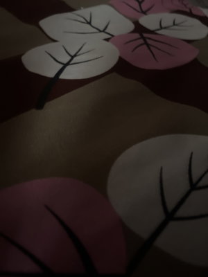 Close-up of patterned fabric with pink and white leaves.