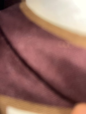 Close-up of purple fabric with gold trim.