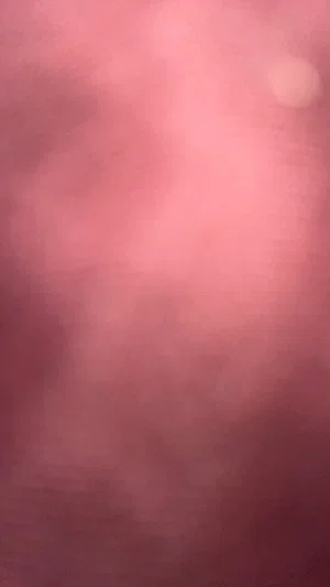 Blurred pink close-up, possibly skin or fabric, no clear subject.