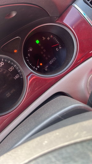 Close-up of red car dashboard with gauges.
