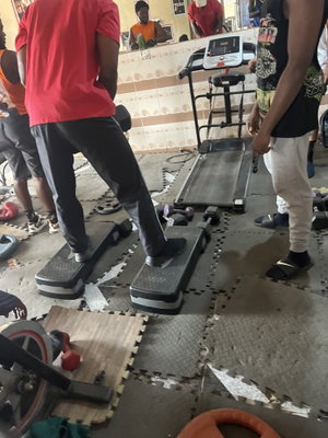 Men in athletic wear exercising on steps in a gym.