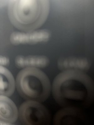 Blurry close-up of circular buttons on dark surface.