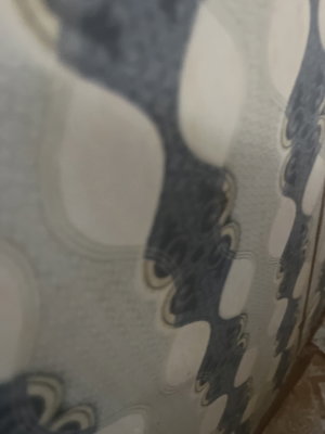 Patterned fabric with abstract blue and white design, possibly wallpaper or curtain.