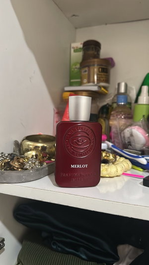 Bathroom shelf with perfume bottle and toiletries.