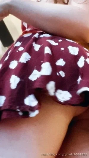 Person in maroon and white polka dot skirt, legs visible, indoor setting.