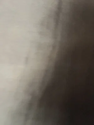 Blurred image with indistinct light and dark areas, no clear person or setting visible.