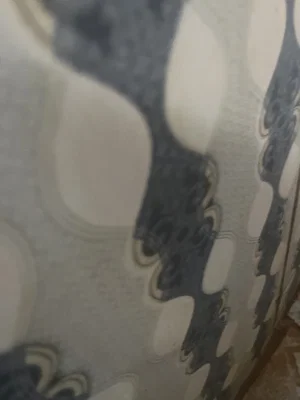Patterned fabric with abstract dark and light shapes.