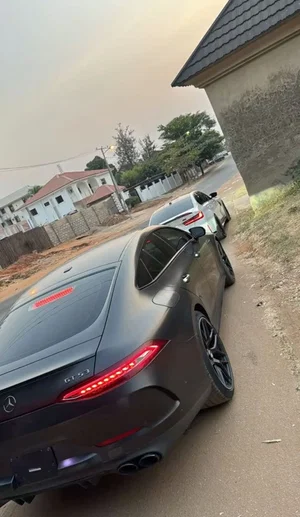Two luxury cars parked on a residential street near a house.