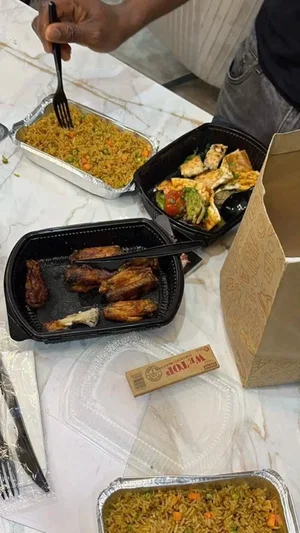 Person eating takeout food from containers on a marble table.