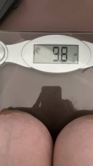 Curvy woman bare buttocks on scale indoors.