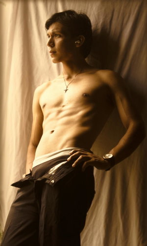 Shirtless fit man with dark hair posing indoors.